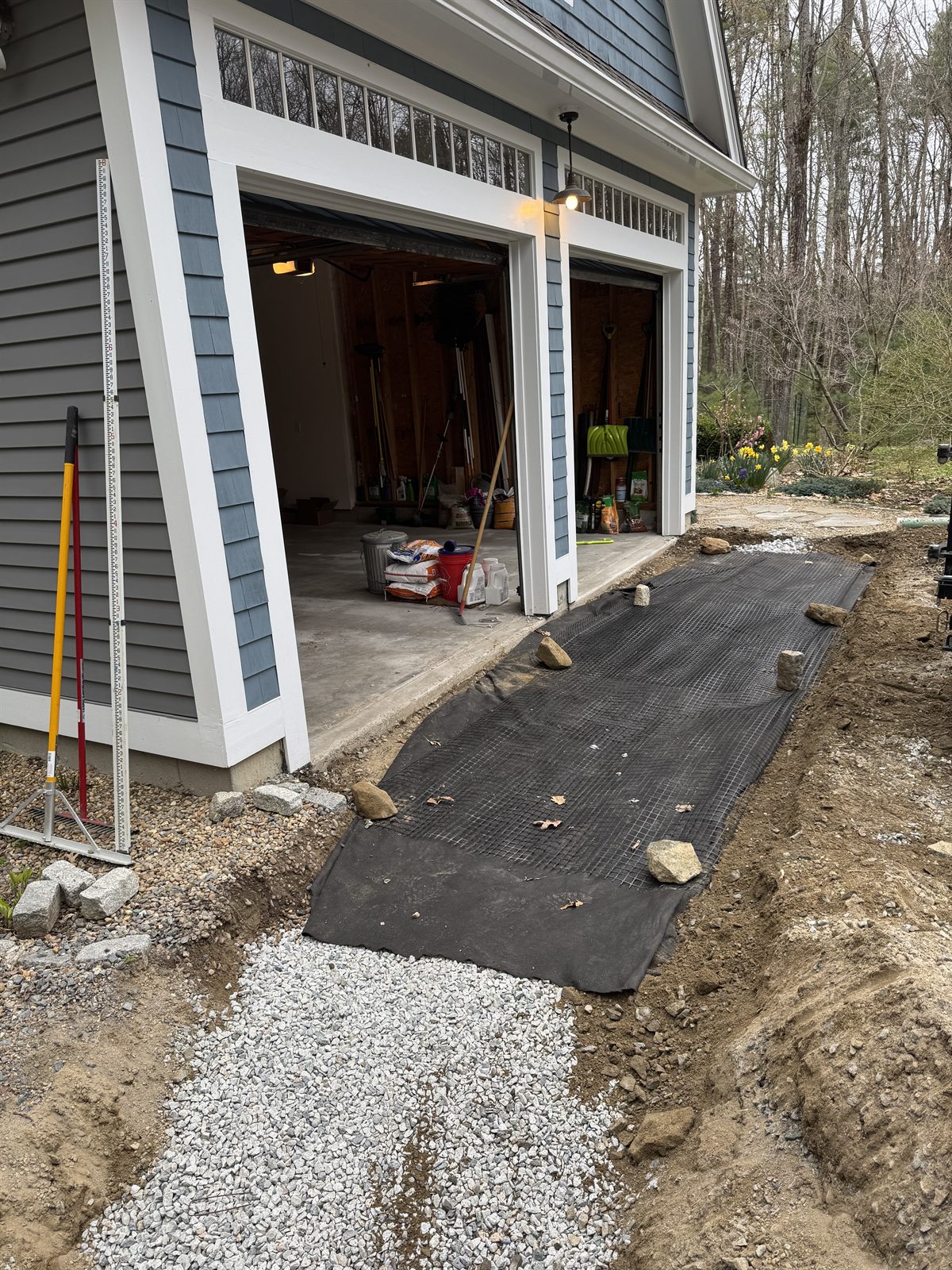 Geotextile fabric against a foundation before stone — the part you never see is what makes it last.