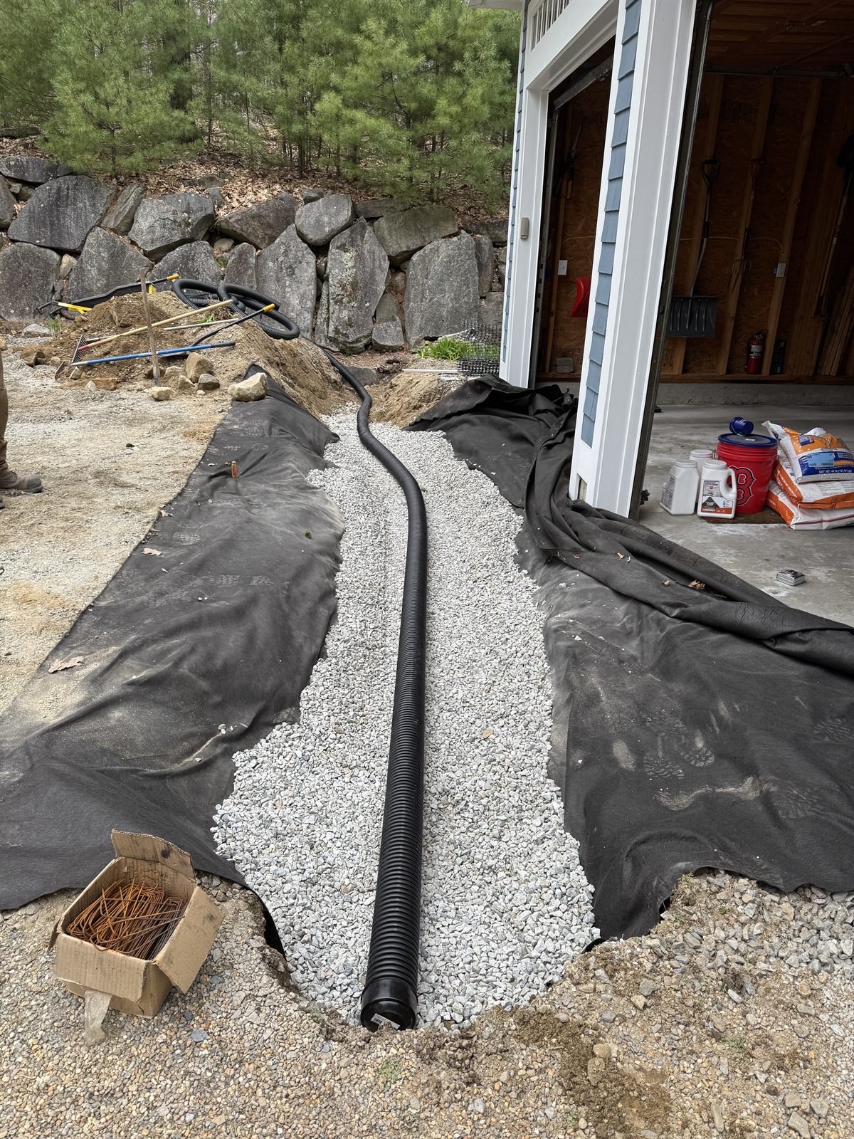 Perforated drain pipe in stone over geotextile before backfill — GSS, Seacoast NH