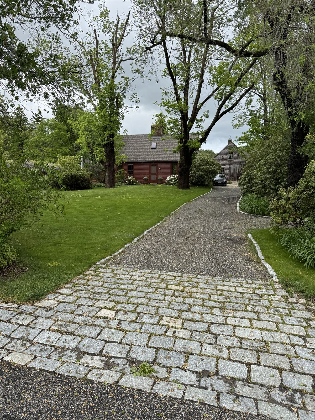 Established lawn meeting a granite cobble driveway apron — GSS Landcrafting, NH